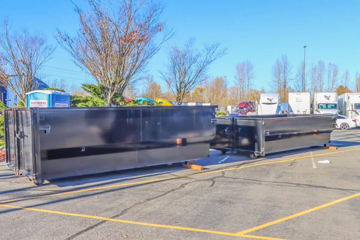 Professional dumpster rental service with roll-off container on residential driveway in Oakland